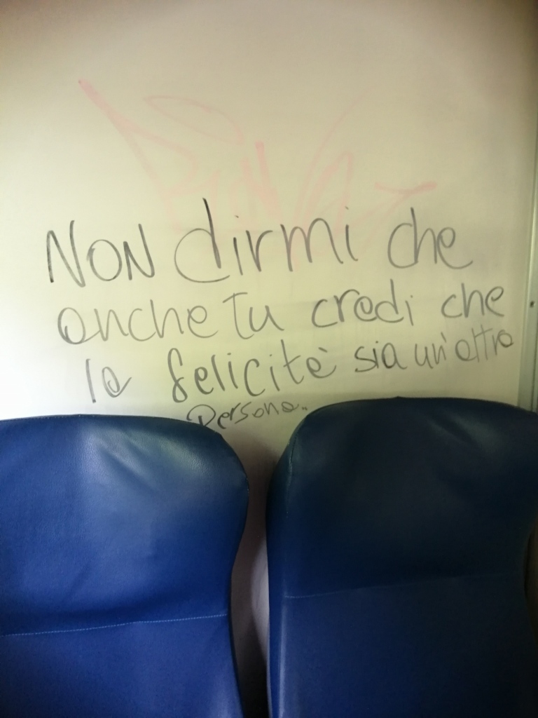 A message on the train in Italian that means, "Don't tell me that you, too believe that happiness is only found in another person."